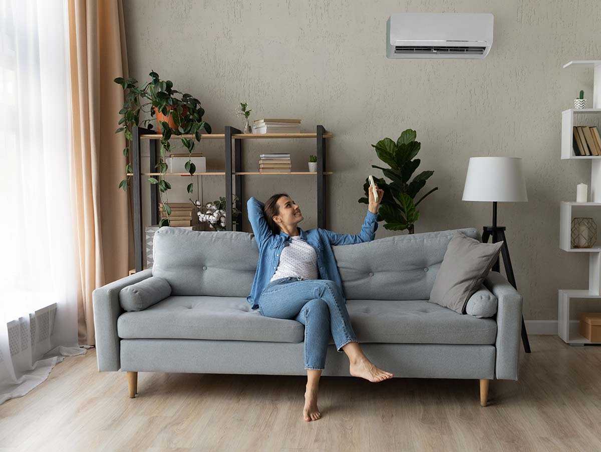 woman adjusts new ac - Air Conditioning Repair and Installation In Bardstown, KY | Above All Mechanical